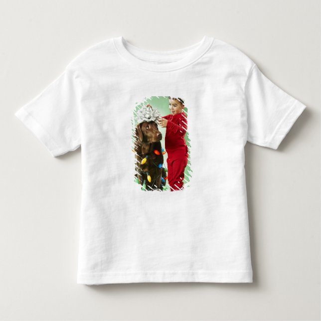 Young boy wrapping Christmas lights around a dog Toddler T-Shirt (Front)