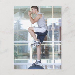 young man doing step-up exercises on a balance postcard