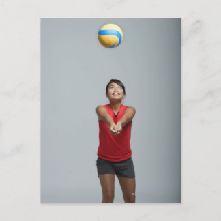 Young woman playing with volleyball postcard