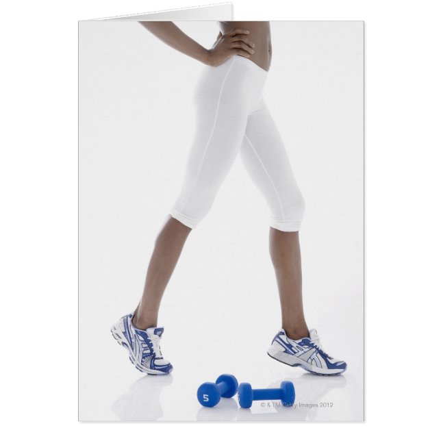 Young woman with dumbbells stretching (low (Front)